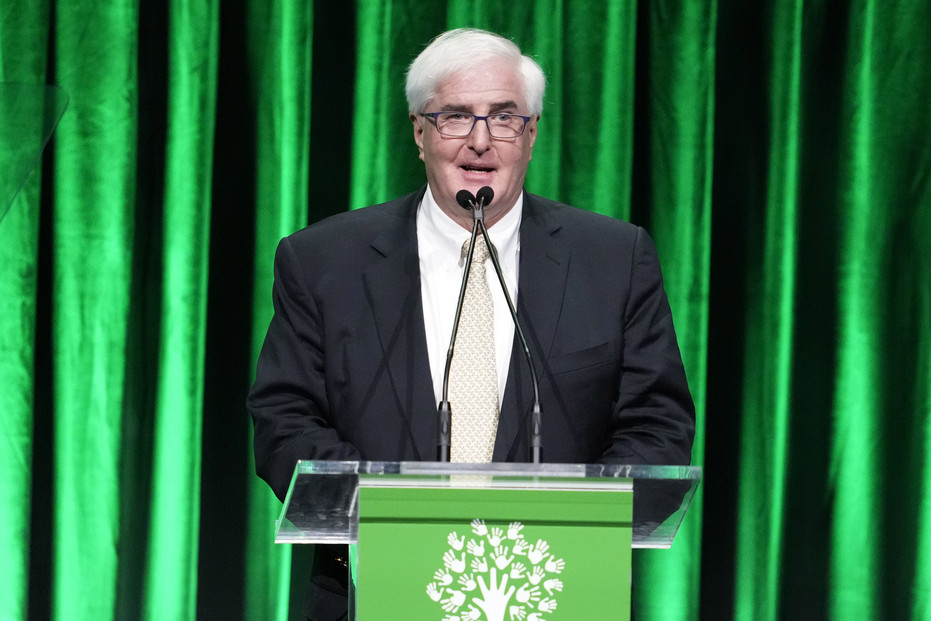 Ron Conway speaks at podium onstage.